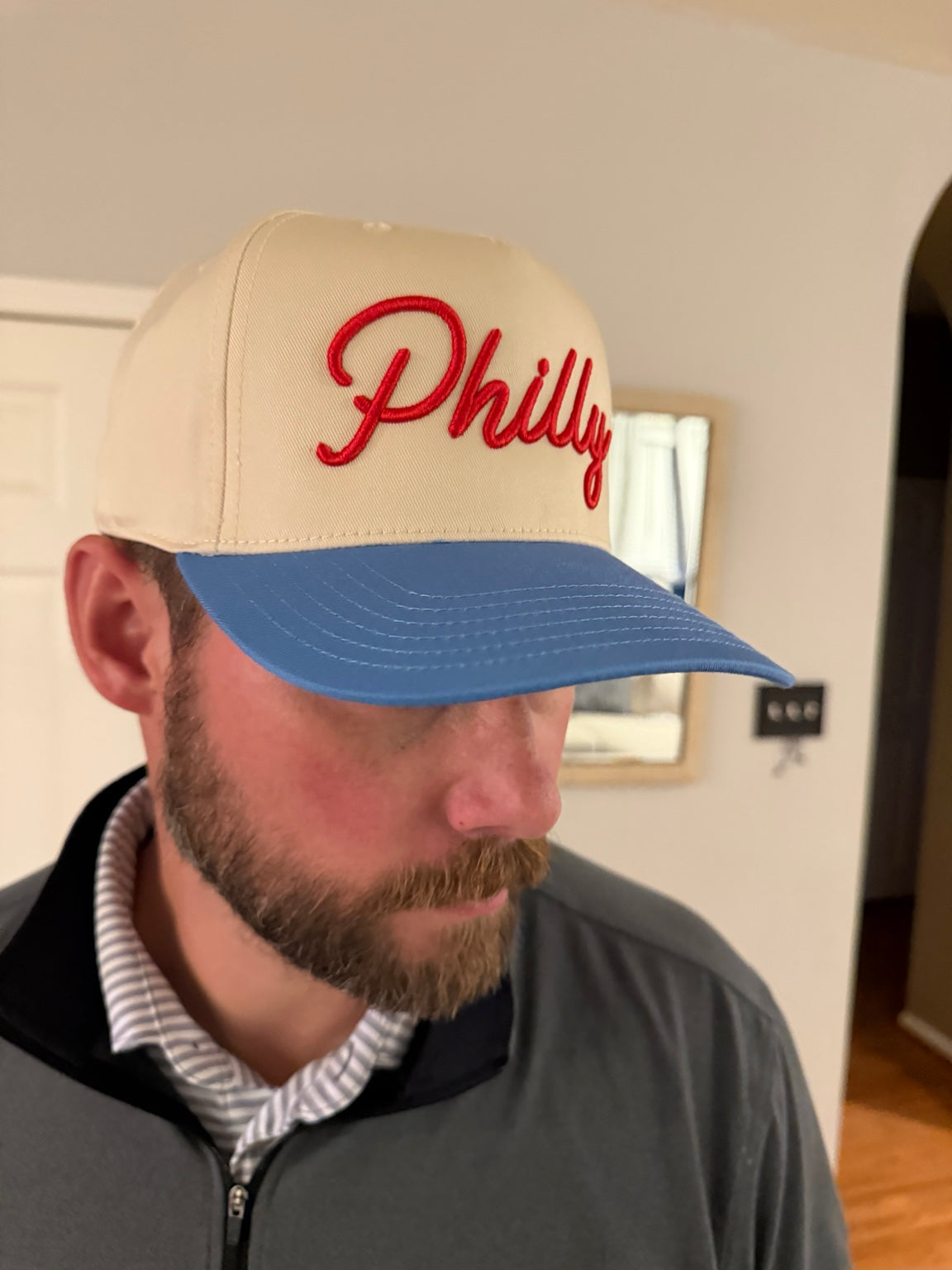 Adult wearing cream and Carolina blue Philly hat with red 3D puff script embroidery