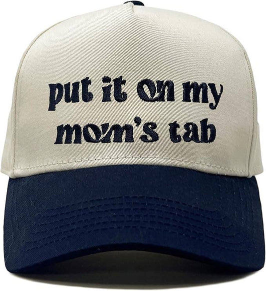 Put It On My Mom’s Tab trucker hat with navy lettering and brim and a cream front
