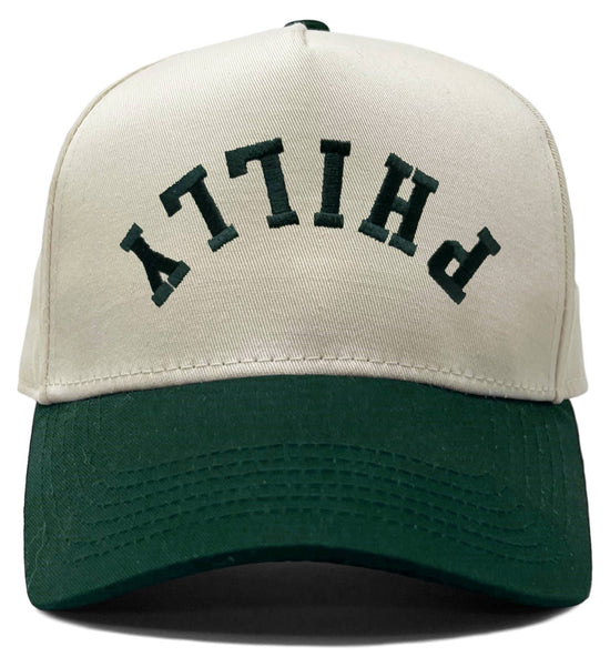 Adult Philly trucker hat with upside-down green lettering, beige front and green brim